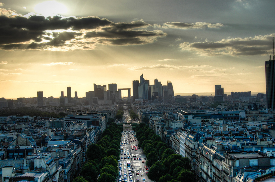 Shot in HDR from the top of the Arc de Triomphe, this shot shows a sunset over the Paris district of La Defense. The square, hollow building at image centre is La Grande Arch, the third arch on the historical axis of Paris.