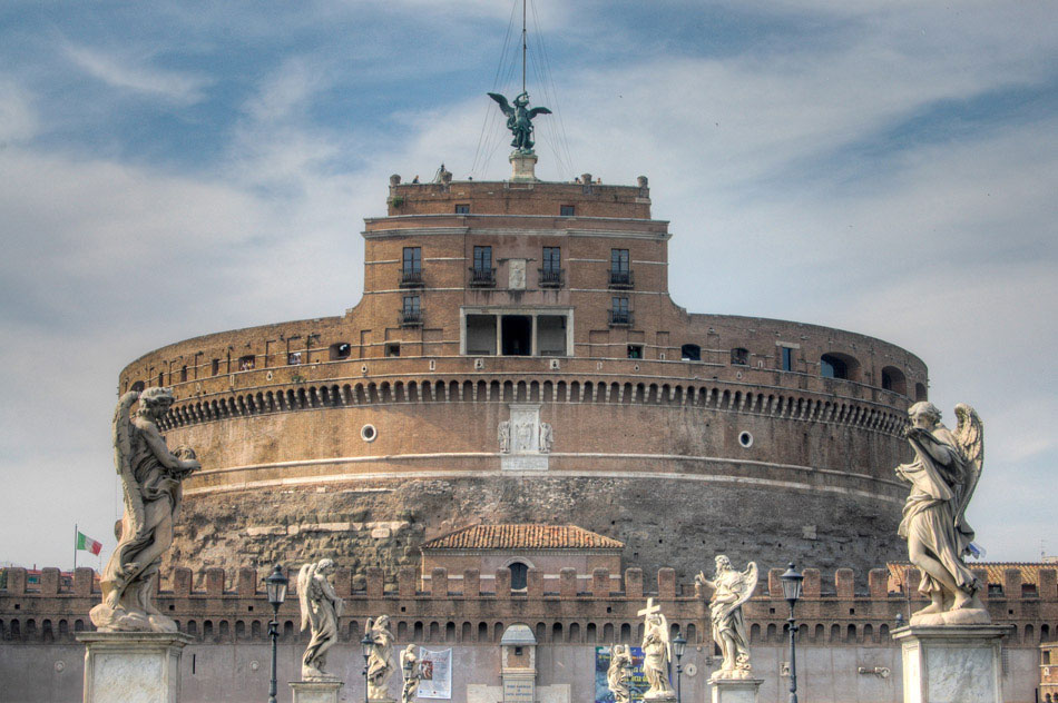 The Castel Sant’angelo as seen from the Ponte Sant’Angelo bridge, leading away from the fortress. Originally built as a mausoleum for Emperor Hadrian and his family, the castle was subsequently used as a papal residence, prison and fortress. It is currently a museum, open to the public.